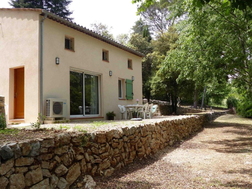 een huis met een stenen muur naast een gebouw bij L'Esquirou in Grasse