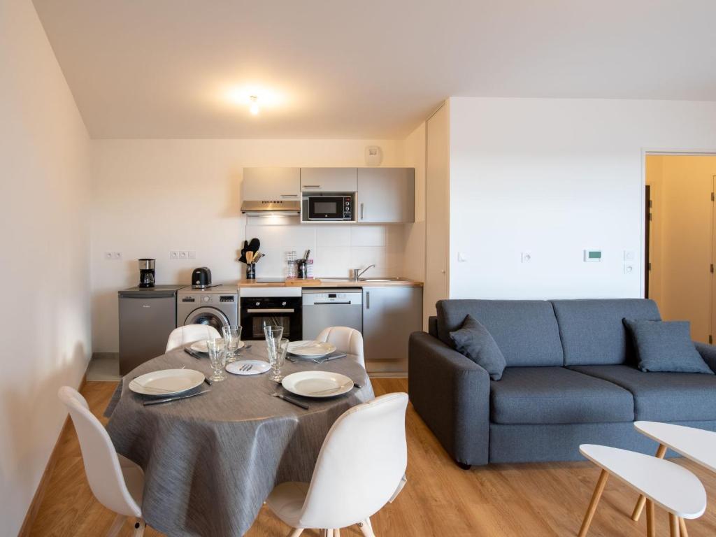 een woonkamer met een tafel en een blauwe bank bij Apartment Les Cavaliers by Interhome in Cabourg