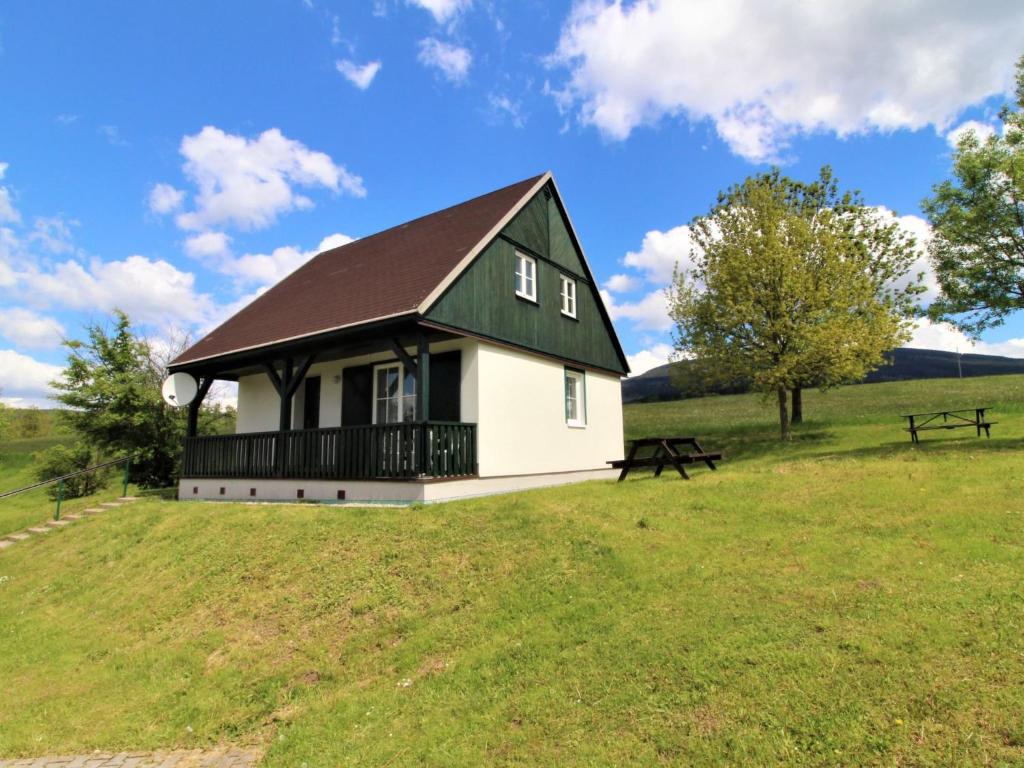 ein weißes Haus mit einem schwarzen Dach auf einem Grasfeld in der Unterkunft Holiday Home Holiday Hill 59 by Interhome in Lauterwasser