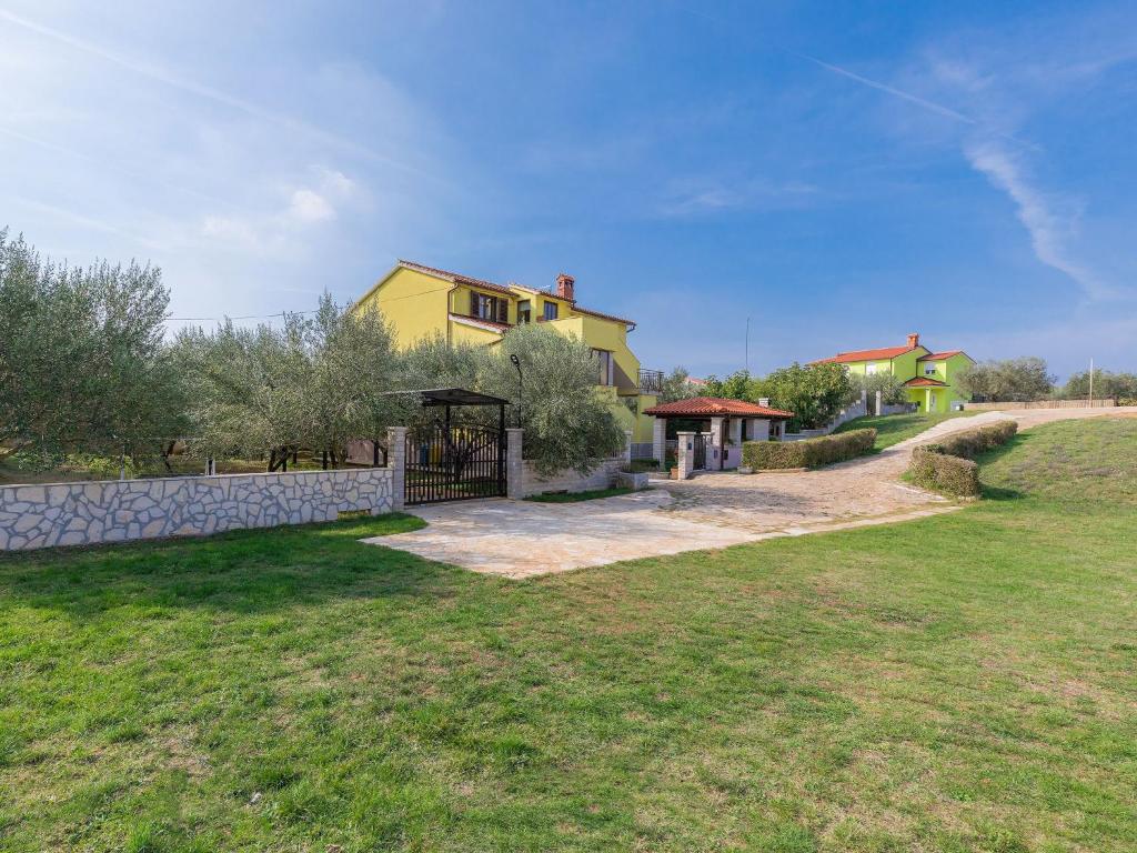 a yellow house with a fence and a yard at Apartment Meden by Interhome in Galižana