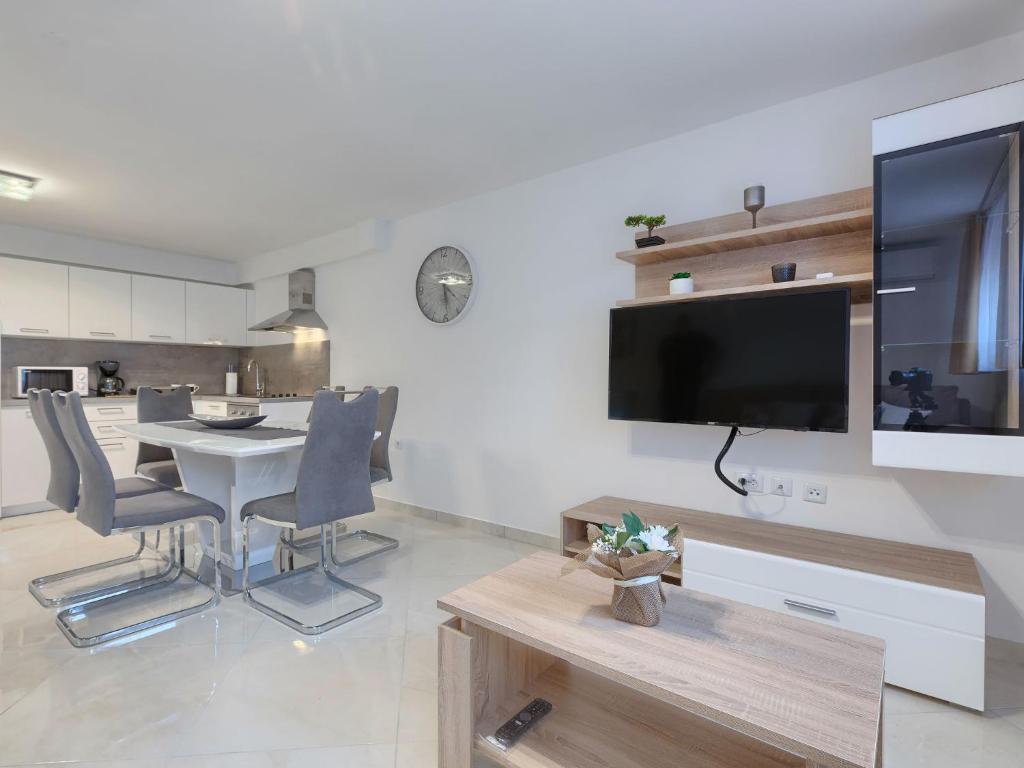 salon ze stołem i telewizorem na ścianie w obiekcie Apartment Meden by Interhome w mieście Galižana