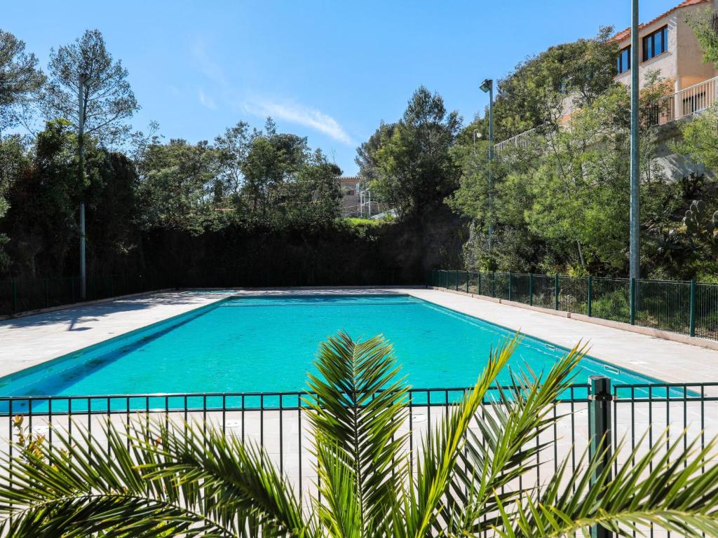 une grande piscine entourée d'une clôture. dans l'établissement Apartment Résidence Les Jardins d'Azur-5 by Interhome, à Saint-Raphaël