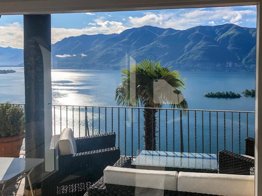 balcone con vista su una palma e sull'acqua di Holiday Home Villetta Irma by Interhome a Ronco sopra Ascona