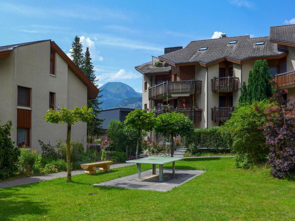 a park in front of a building with a picnic table at Apartment Allmi by Interhome in Meiringen