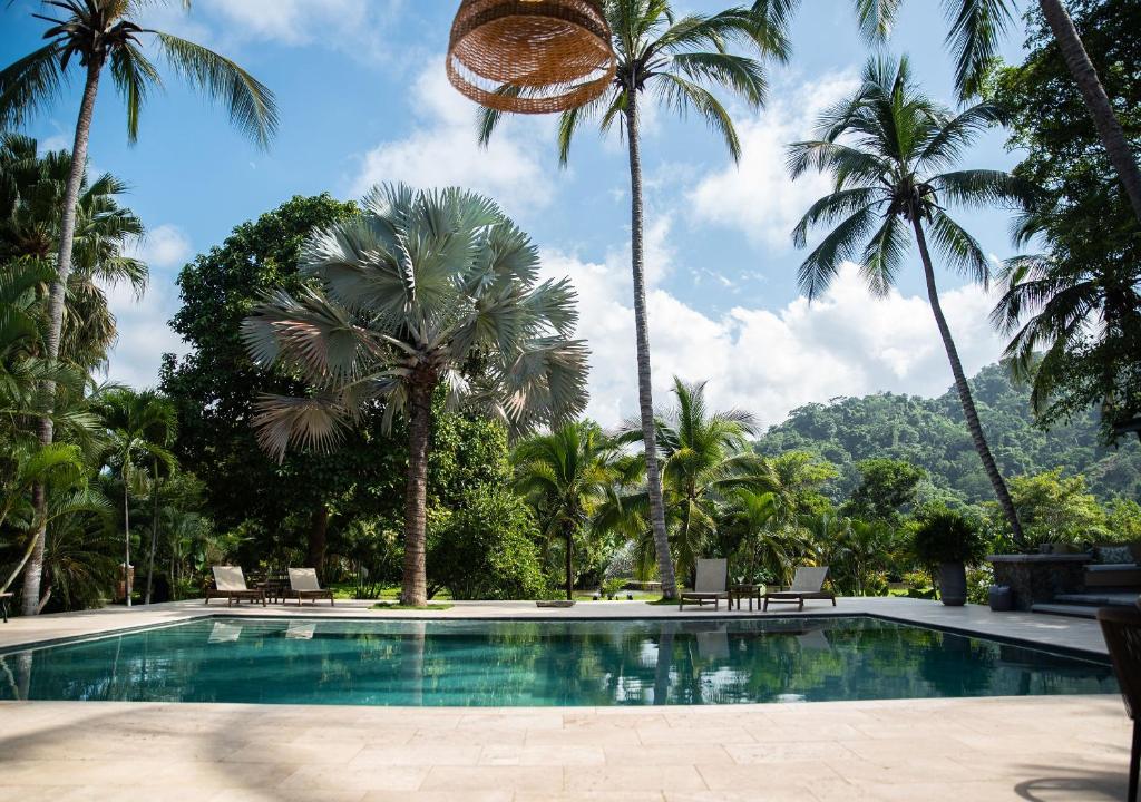 einen Pool mit Palmen in einem Resort in der Unterkunft Hotel La Finca Buritaca by DOT Premium in Buritaca