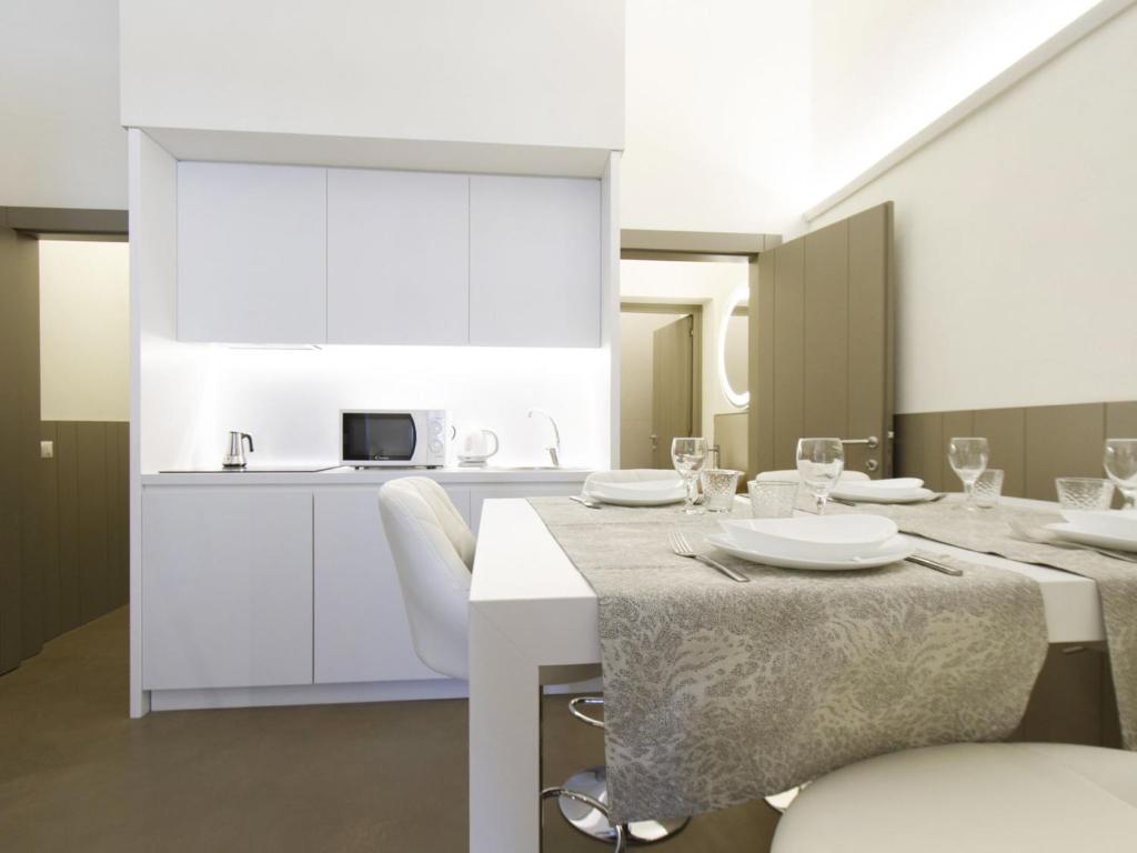 una sala da pranzo con tavoli bianchi e sedie bianche di Apartment Tipologia Trilo 06 pax by Interhome a Firenze