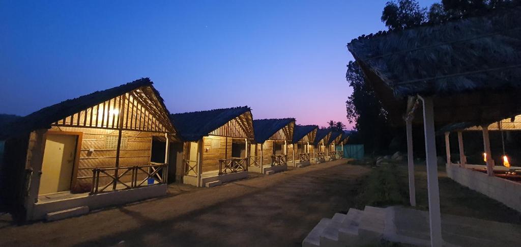 una fila di edifici in legno di notte di Lazy Panda a Hampi