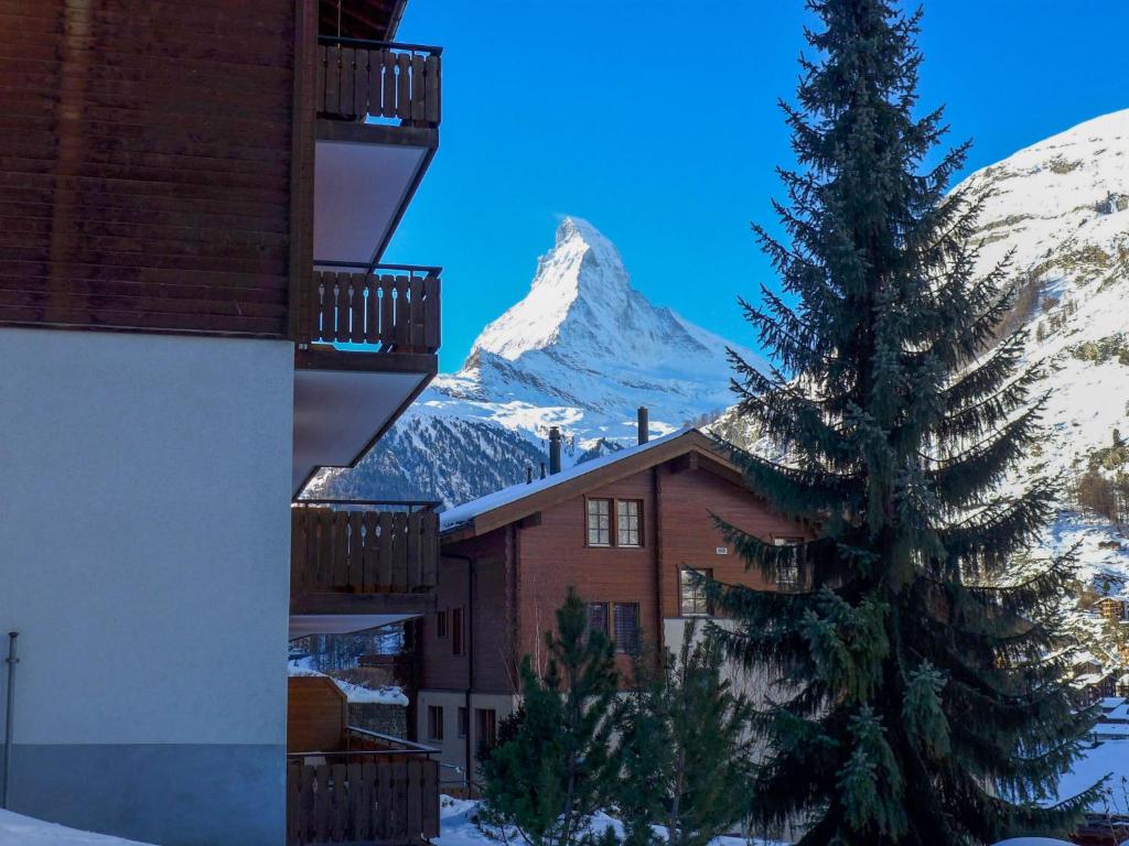 een gebouw met een met sneeuw bedekte berg op de achtergrond bij Apartment Shangri La by Interhome in Zermatt