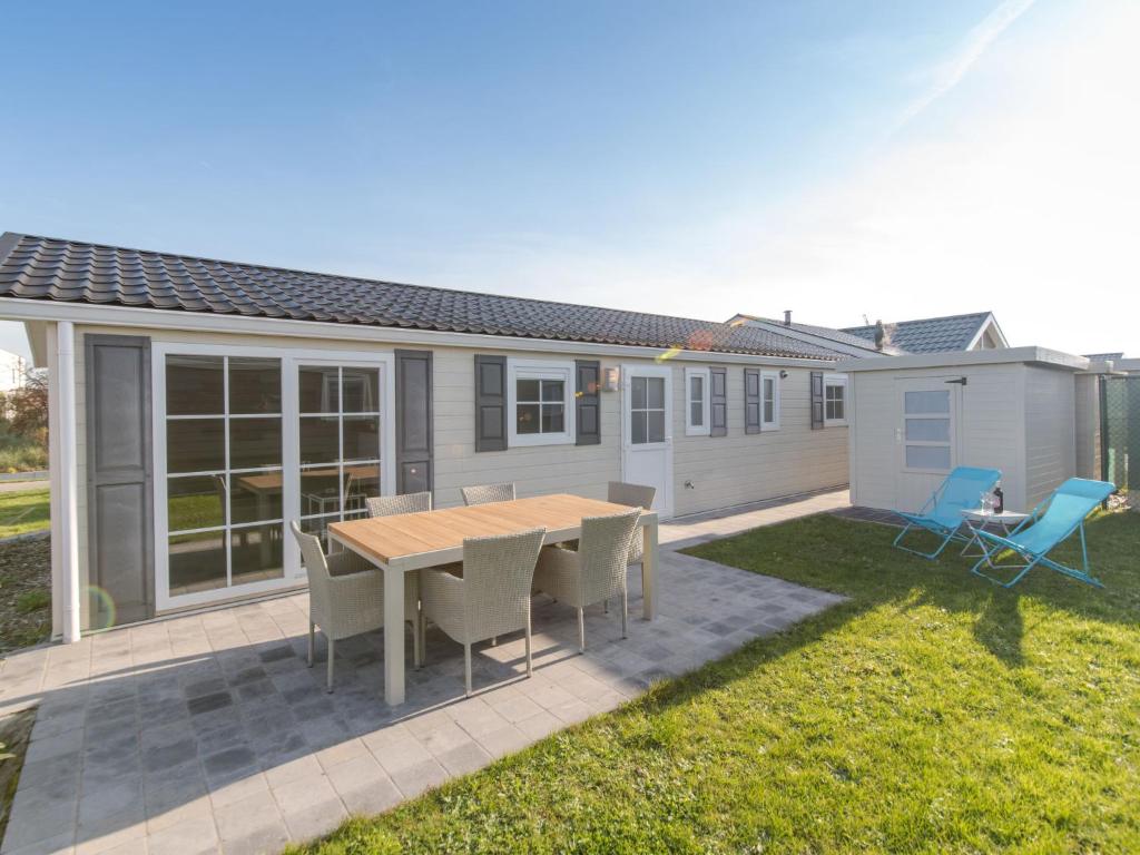 a patio with a table and chairs in a yard at Holiday Home Park Kerlinga-20 by Interhome in Bredene