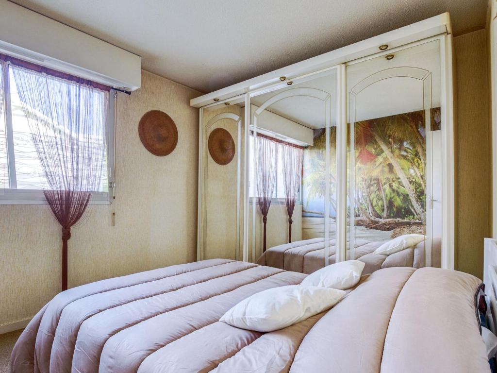 une chambre avec deux lits et un tableau au mur dans l'établissement Apartment Villa Spring by Interhome, à Arcachon