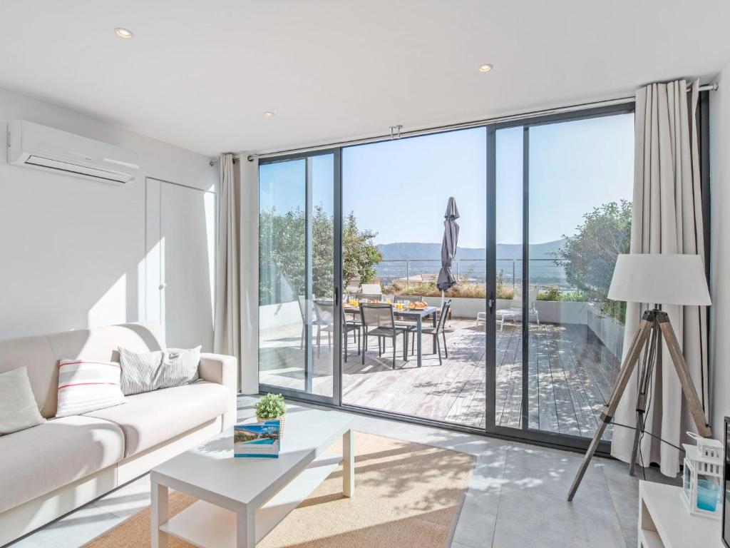 un salon avec un canapé blanc et une grande fenêtre dans l'établissement Apartment château by Interhome, à Porto-Vecchio