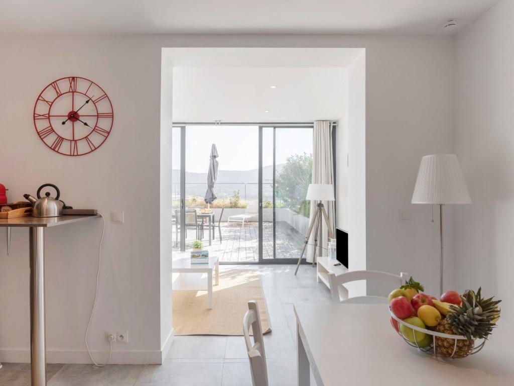 eine Küche und ein Esszimmer mit einer Uhr an der Wand in der Unterkunft Apartment Le Palazzu-21 by Interhome in Porto-Vecchio