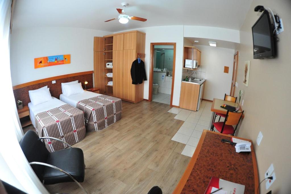 Habitación de hotel con 2 camas y TV en Union Residence HEER, en Novo Hamburgo