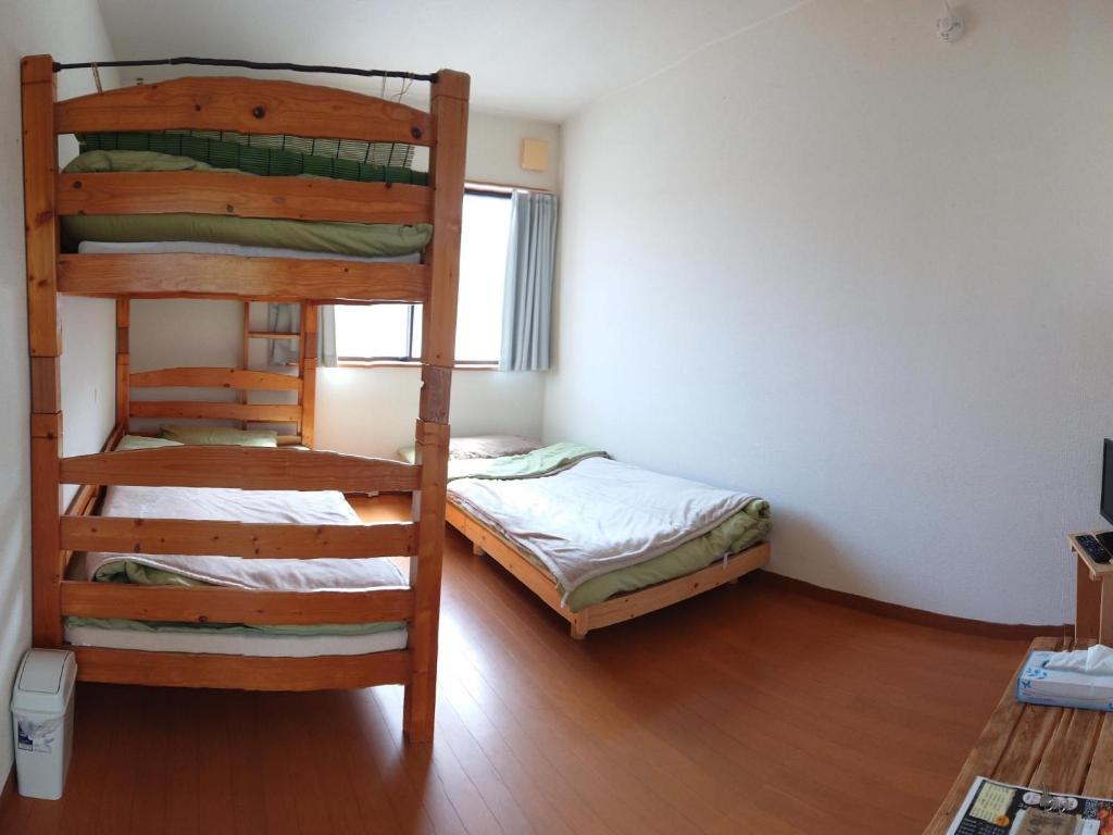 a bedroom with two bunk beds and a bed at ＬＯＤＧＥ ｎ"ｔｒｉｂｅ - Vacation STAY 91085v in Nichinan
