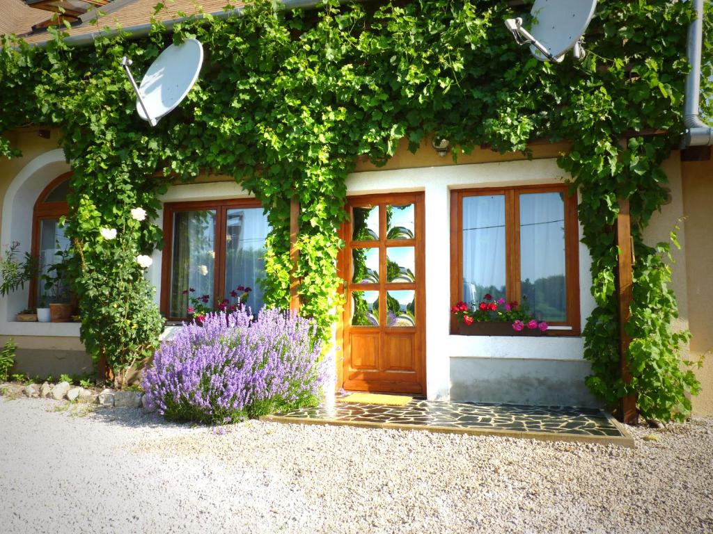 una casa con una puerta y flores delante de ella en Dorka vendégház, en Kehidakustány