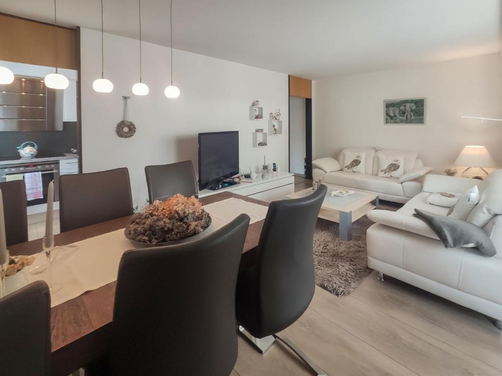 a dining room and living room with a table and chairs at Apartment Allod Park Haus C 207 by Interhome in Davos
