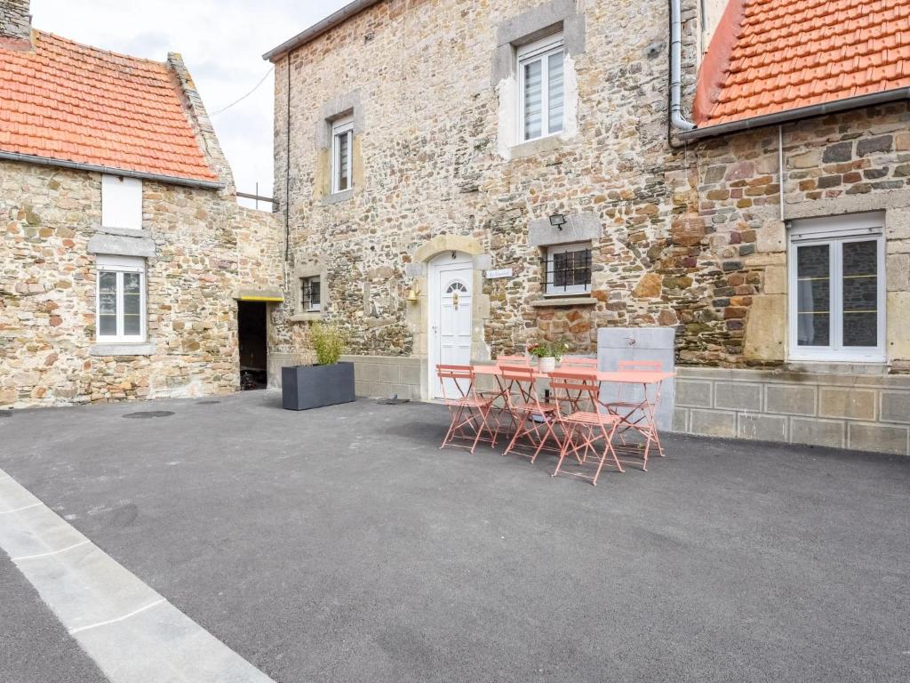 un patio avec une table et des chaises devant un bâtiment dans l'établissement Holiday Home L'oyat by Interhome, à Pirou