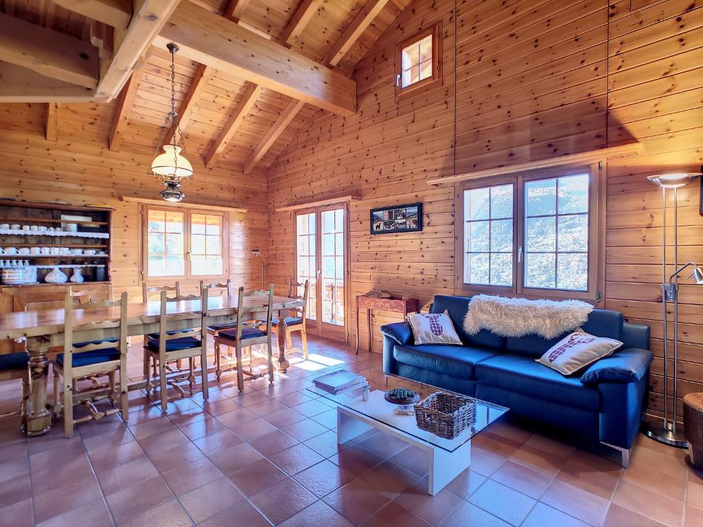 ヴェゾナにあるChalet Les 4 Saisons by Interhomeの青いソファとテーブルのあるリビングルーム