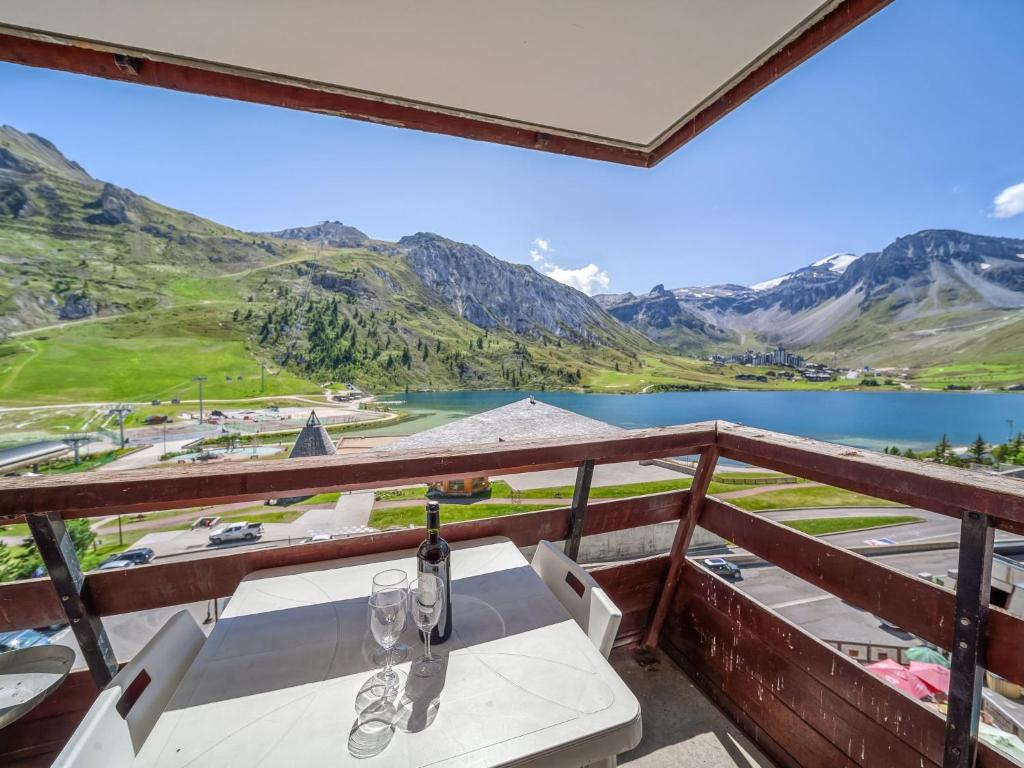 a table with wine glasses on a balcony overlooking a lake at Studio Palafour - Le Lac-4 by Interhome in Tignes