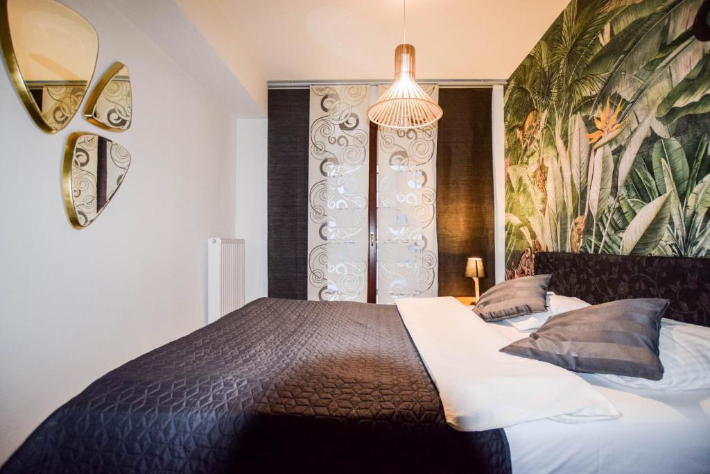 a bedroom with a bed and a wall with a painting at Apartments Blue Angel, park free, children stay free in Krakow