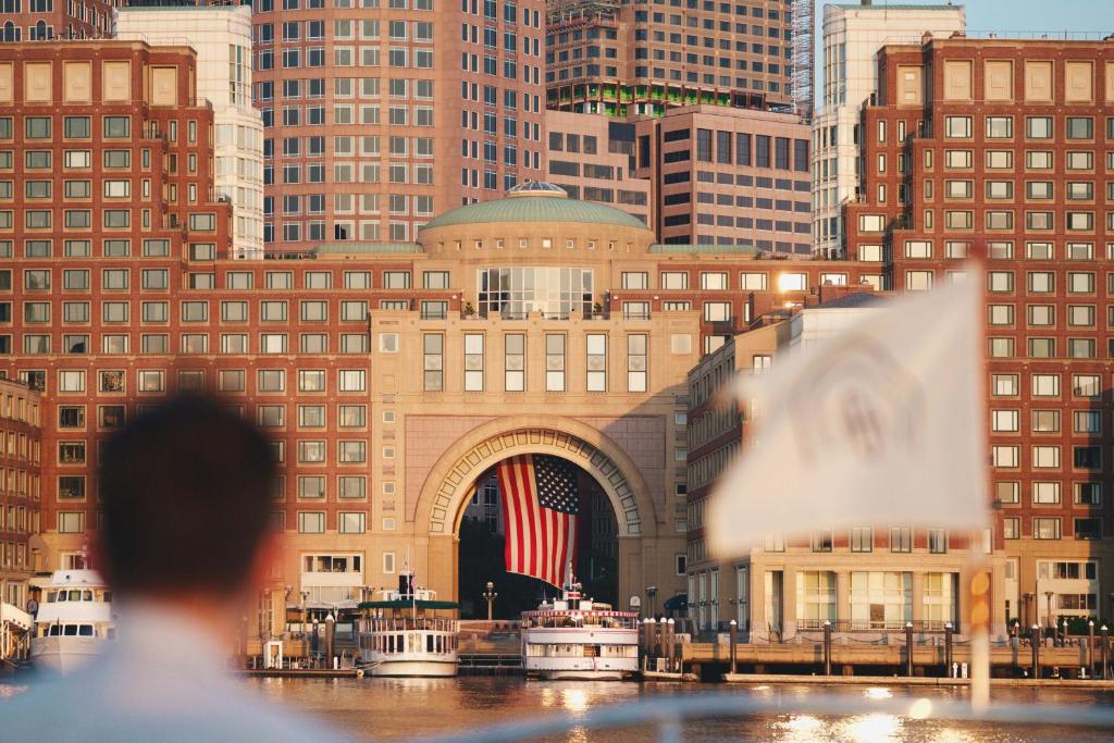 um edifício com uma bandeira americana em frente a uma cidade em Boston Harbor Hotel em Boston