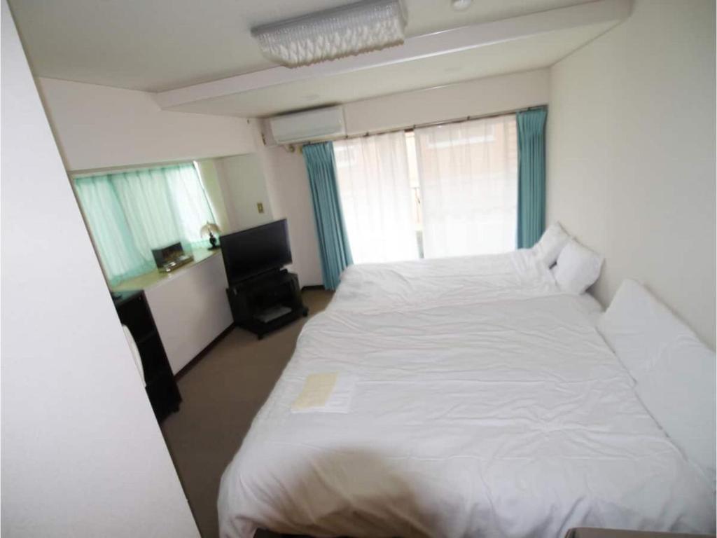 a large white bed in a room with windows at T-Port - Vacation STAY 12338 in Toyama