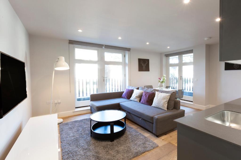 uma sala de estar com um sofá e uma mesa em Hampden Apartments - The Anne em Windsor