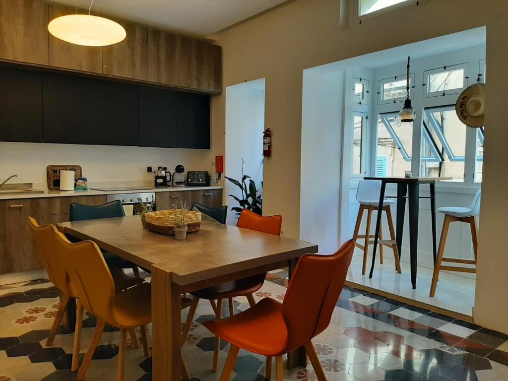 a kitchen and dining room with a wooden table and chairs at Hammock Vibes Town House in Sliema