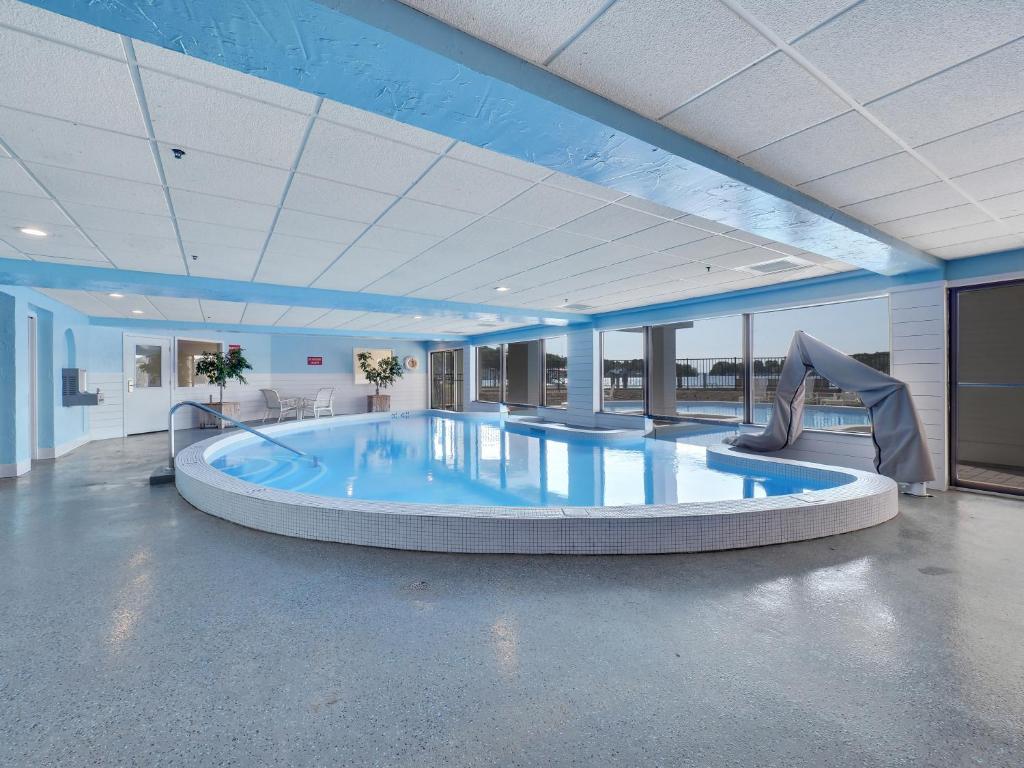 a large swimming pool with a slide in a building at 226 Edgewater Inn in Charlevoix