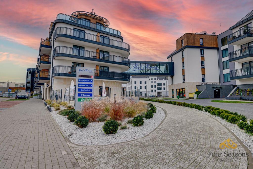 a building with a sunset in the background at Bel Mare Prestige by Four Seasons in Międzyzdroje