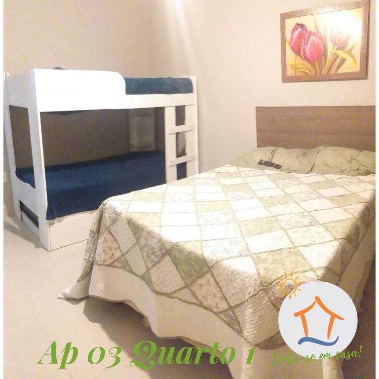 een slaapkamer met een stapelbed met een sprei bij Sentir-se em Casa! Ap Privativo 10min da praia de Itaparica in Vila Velha