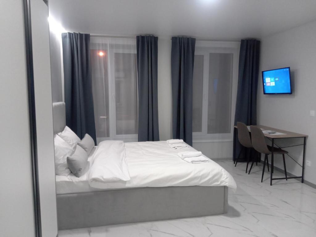 1 dormitorio con cama, escritorio y espejo en 39 Apart Hotel, en Leópolis