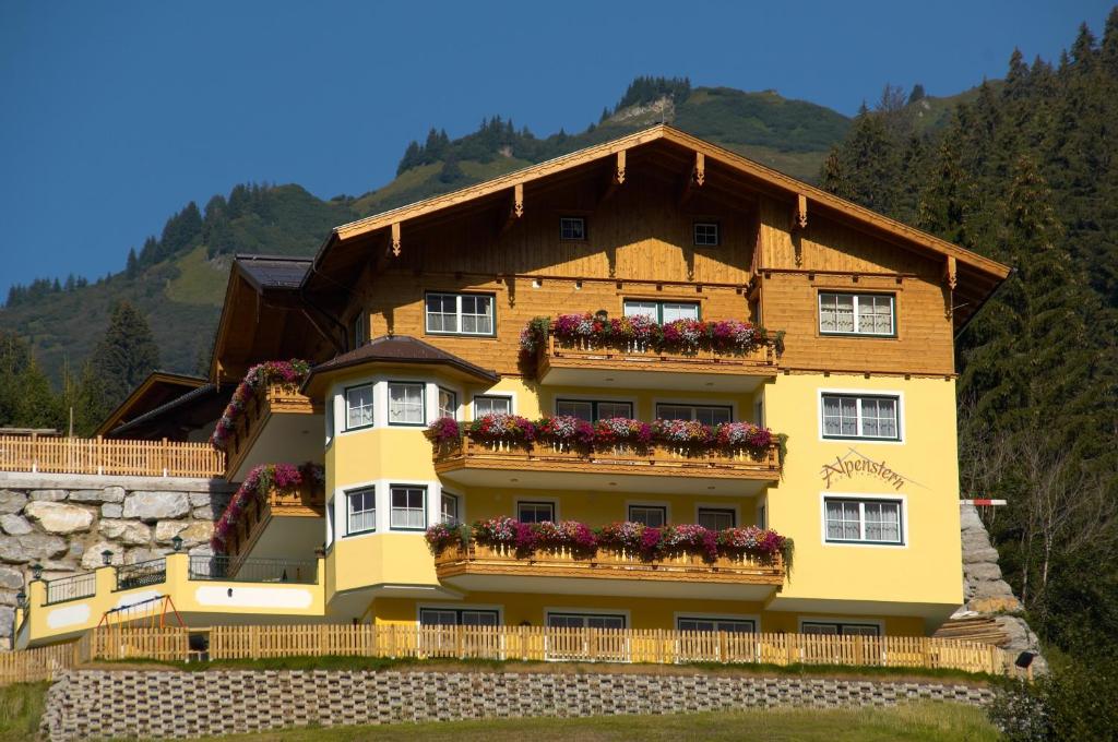 um edifício amarelo com caixas de flores em Appartement Alpenstern em Grossarl