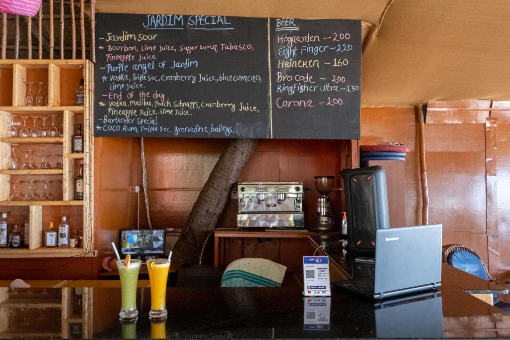 a restaurant with a chalkboard on the wall at Jardim a Mar in Agonda