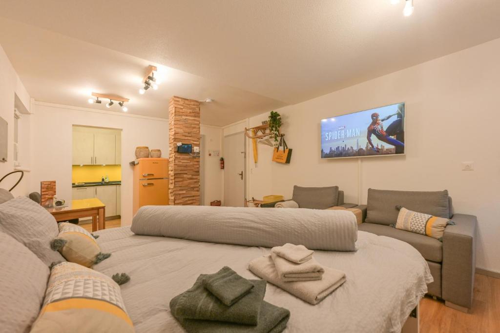 un soggiorno con un divano e una TV a parete di Ambassador Yellow Home a Grächen