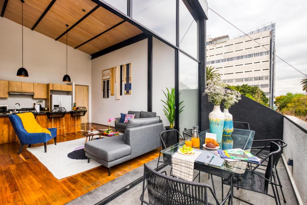 uma sala de estar com um sofá e uma mesa em ULIV Condesa em Cidade do México
