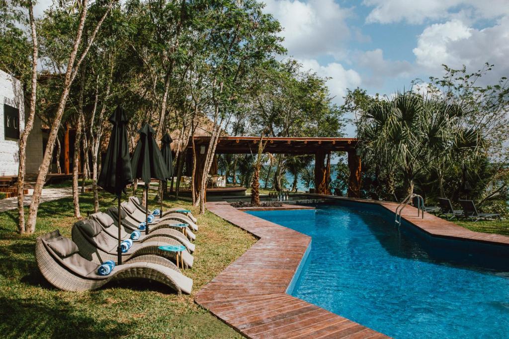 a swimming pool with lounge chairs next to a resort at Mia Bacalar Luxury Resort & Spa in Bacalar