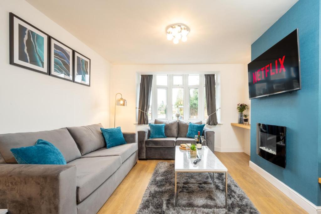 sala de estar con sofá y TV en Treetops House -Luxury modern 4-bed, sleeps 10 -Solihull, JLR, NEC, Resorts World, Birmingham Airport, HS2, en Solihull