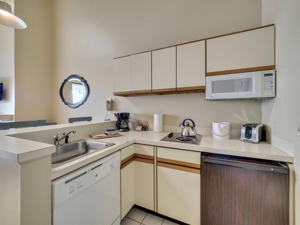 a kitchen with white cabinets and a sink at 347 Edgewater Inn in Charlevoix