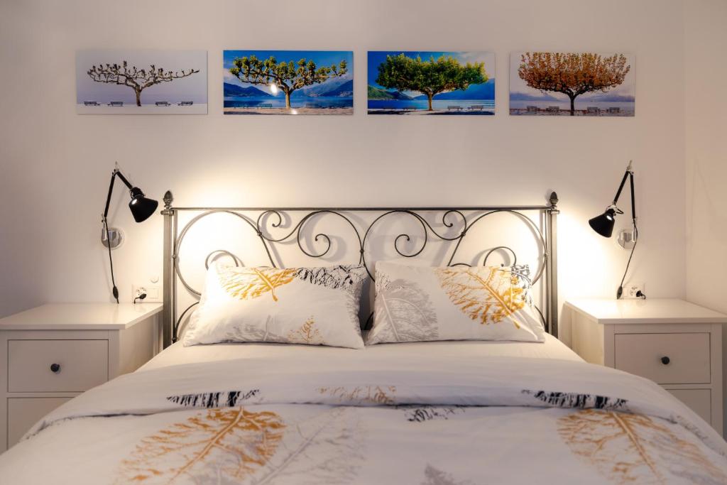 a bedroom with a bed with three pictures on the wall at Casa Alice Ascona, appartamento di vacanza. in Ascona