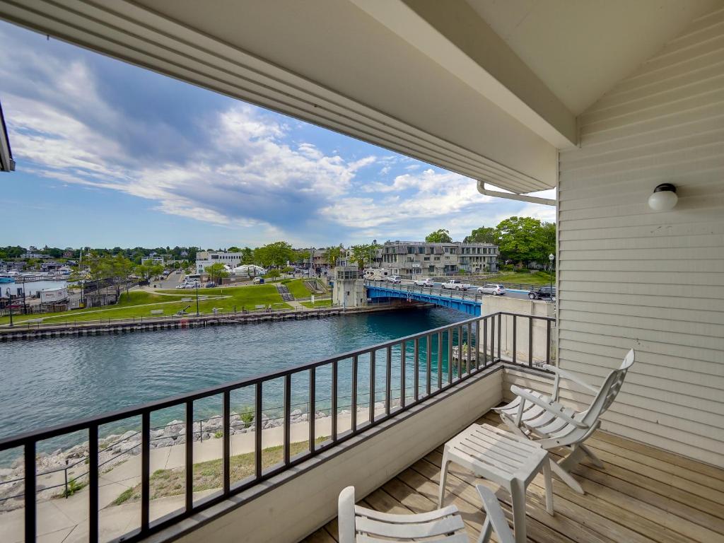 a balcony with two chairs and a view of the water at 358 Edgewater Inn in Charlevoix