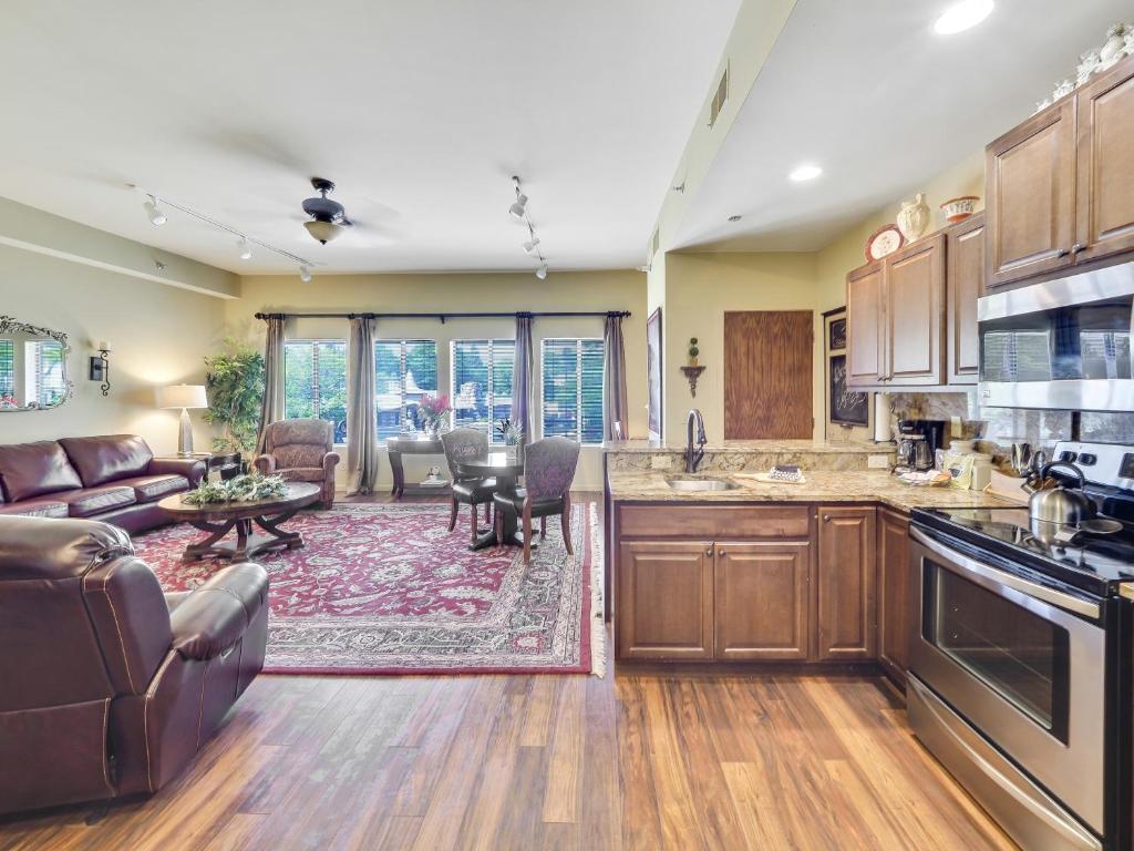 a kitchen with wooden cabinets and a living room at 377 Edgewater Inn in Charlevoix
