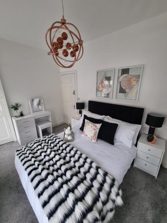 sypialnia z dużym łóżkiem z czarno-białym kocem w obiekcie Bronallt luxury w mieście Mountain Ash