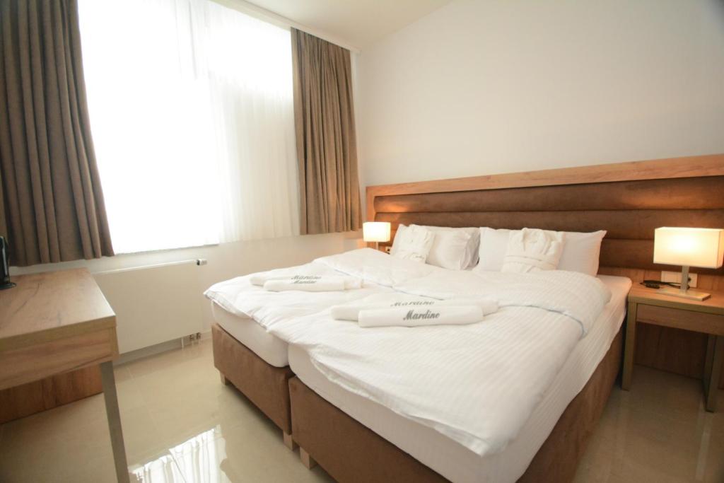 een hotelkamer met een groot bed met twee handdoeken erop bij Hannover Zimmervermietung Mardino in Hannover