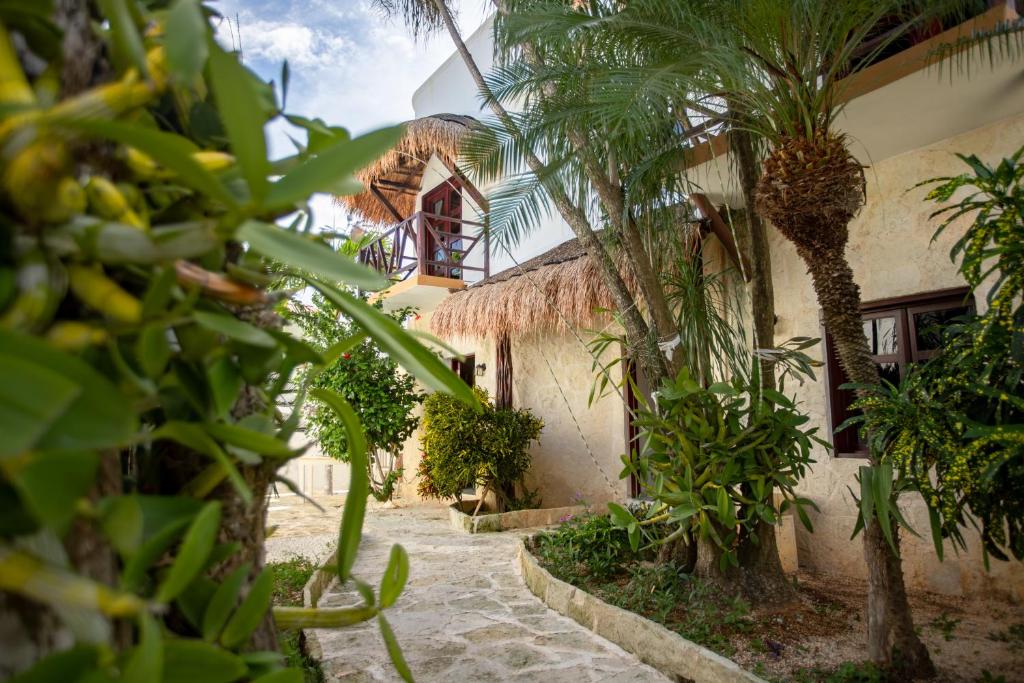 a courtyard with palm trees and a building at Howlita Tulum - Adult Only in Tulum