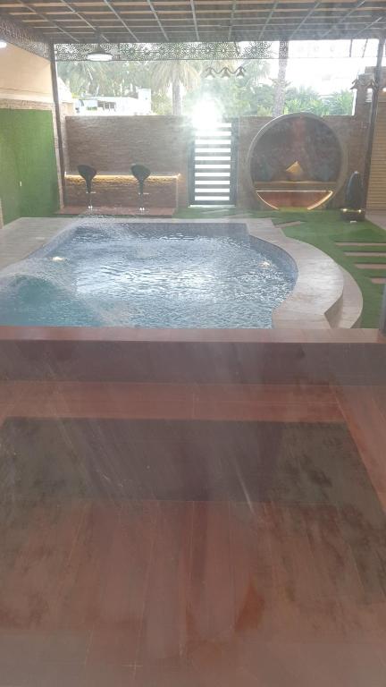 a small swimming pool in a room with a table at شاليه الشهد in Ma‘ābīlah