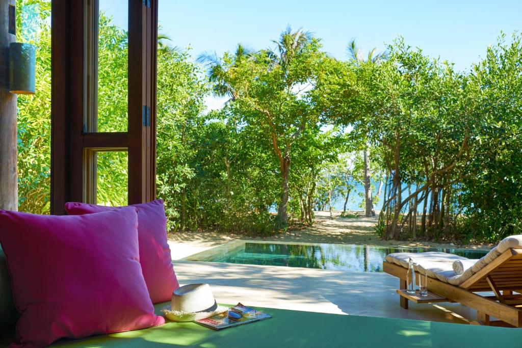 a living room with a view of a swimming pool at Six Senses Ninh Van Bay in Ninh Van Bay