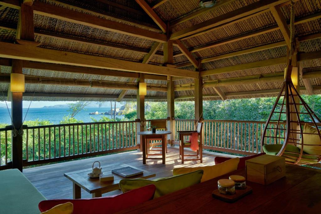 a living room with a balcony with a table and chairs at Six Senses Ninh Van Bay in Ninh Van Bay