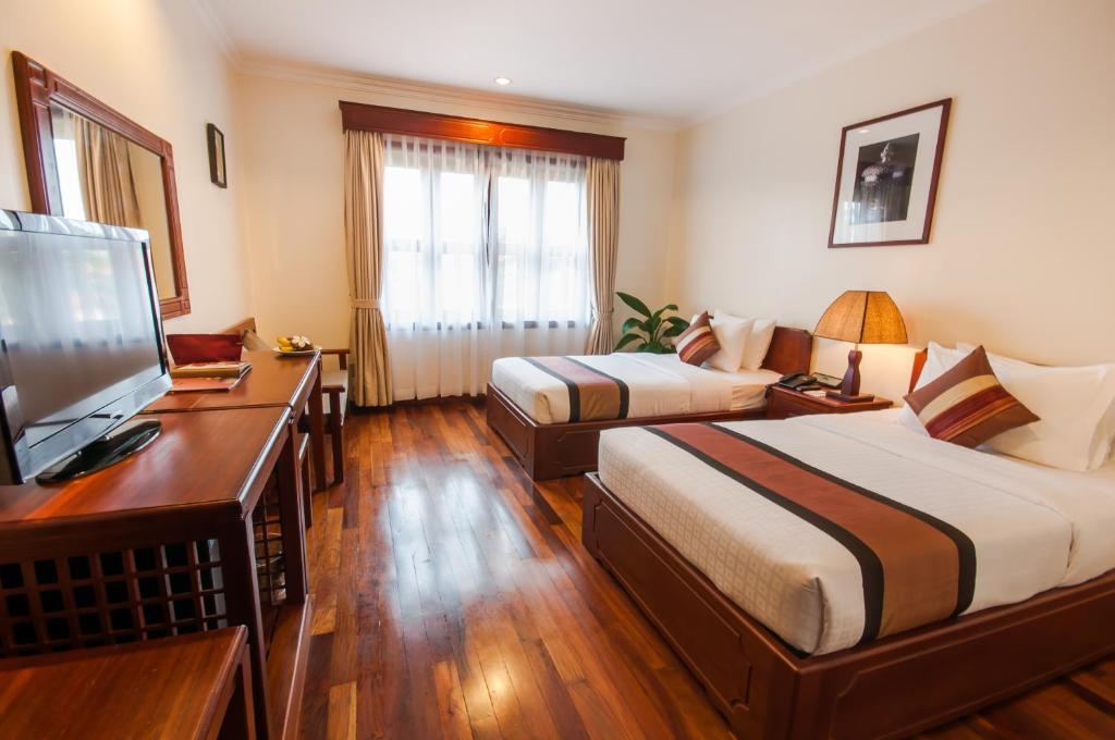 Postel nebo postele na pokoji v ubytování Saem Siemreap Hotel