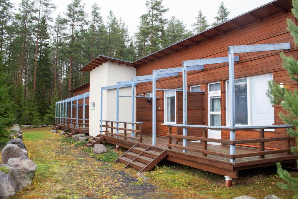 eine Hütte im Wald mit einer großen Terrasse in der Unterkunft Jokiniemen Matkailu in Alapitkä